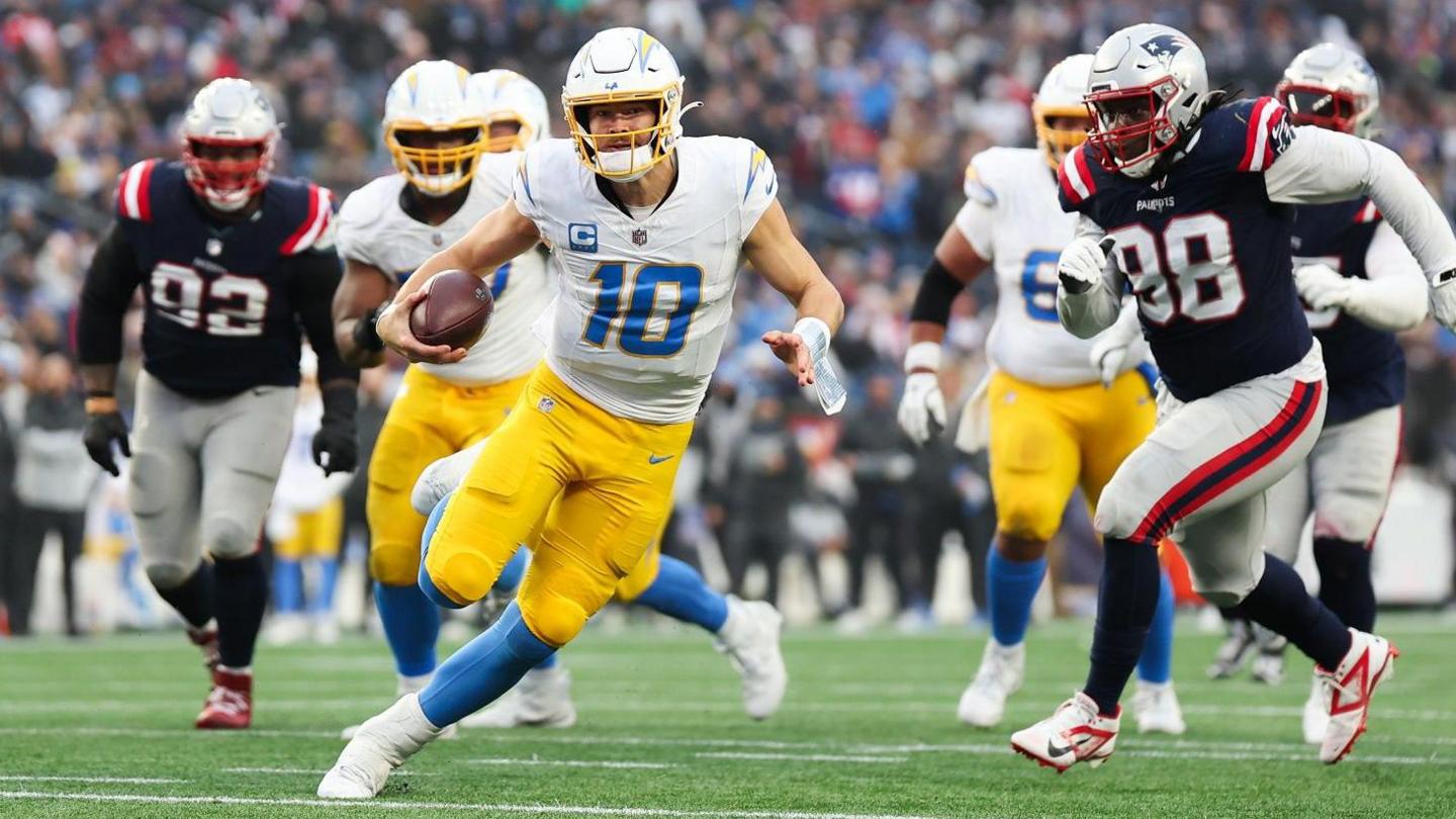 Justin Herbert of the Los Angeles Chargers runs with the football 