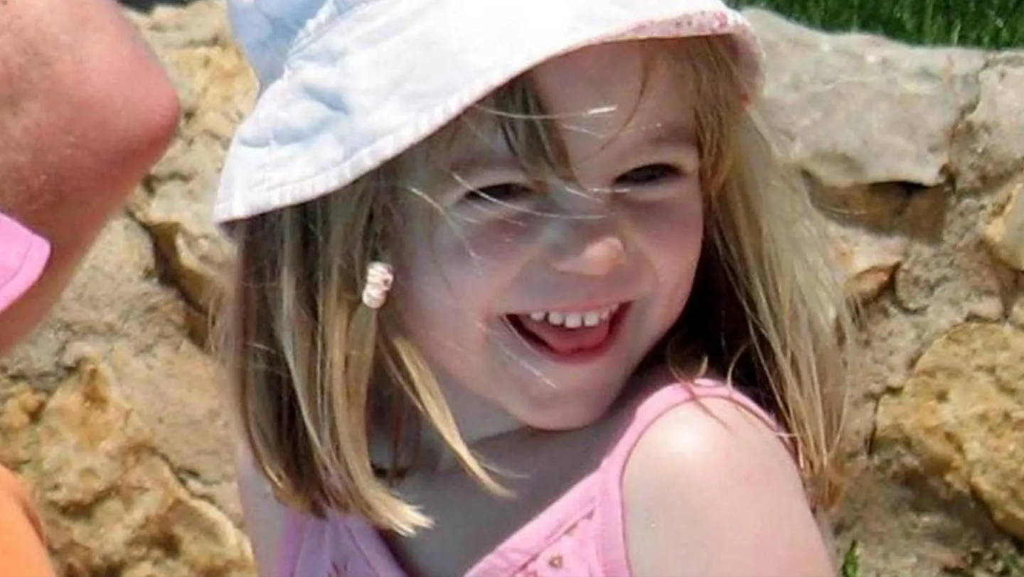 Madeleine McCann wearing a pink top and a white sun hat