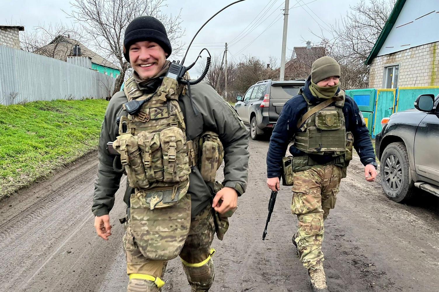 Eugene smiling in military gear with a comrade