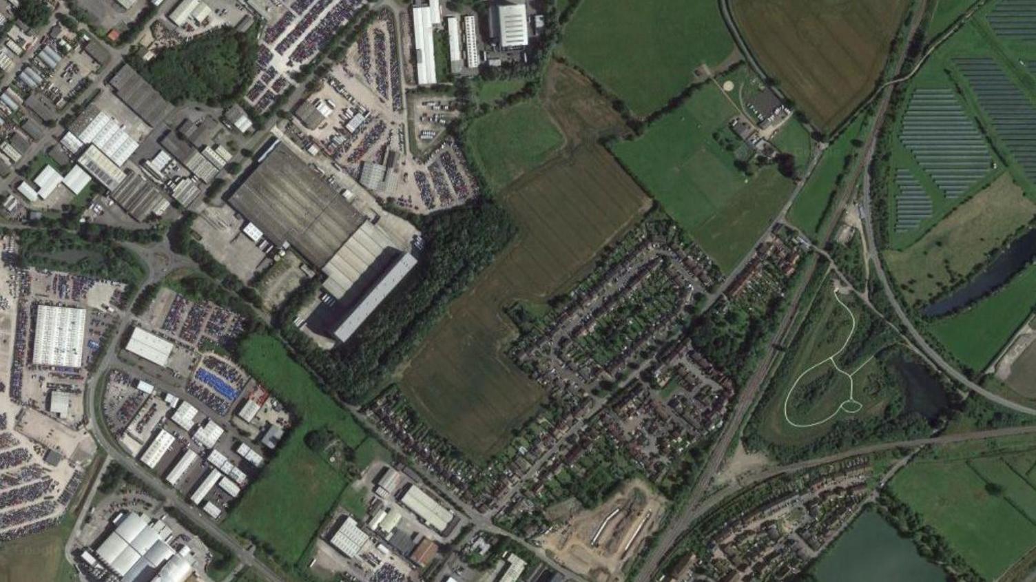 An aeriel view of the site where the homes would have been built showing some streets of housing on one edge of the site and the West Wiltshire Trading Estate on the other.