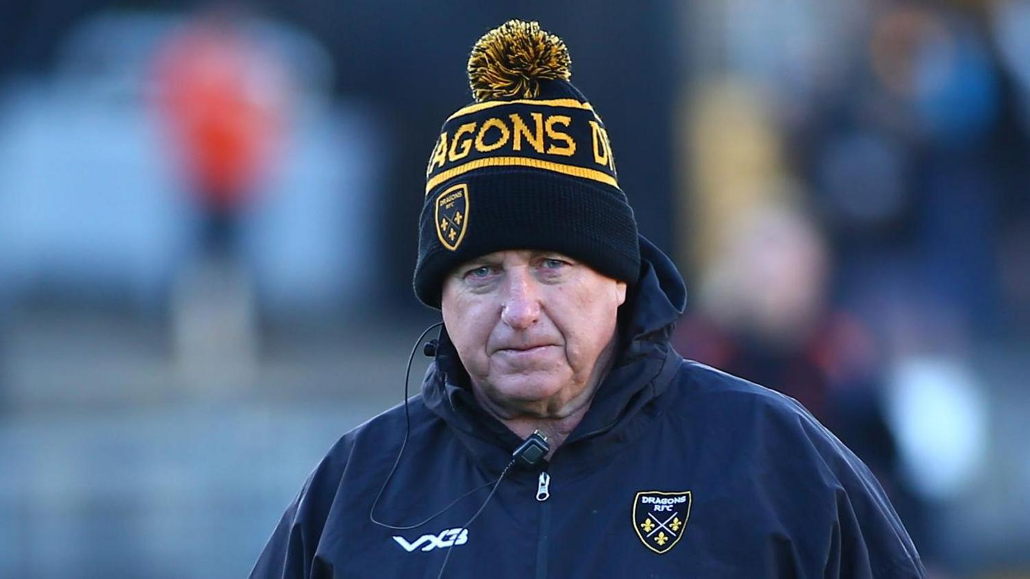 Dale Macleod with Dragons bobble hat and jacket and microphone headset