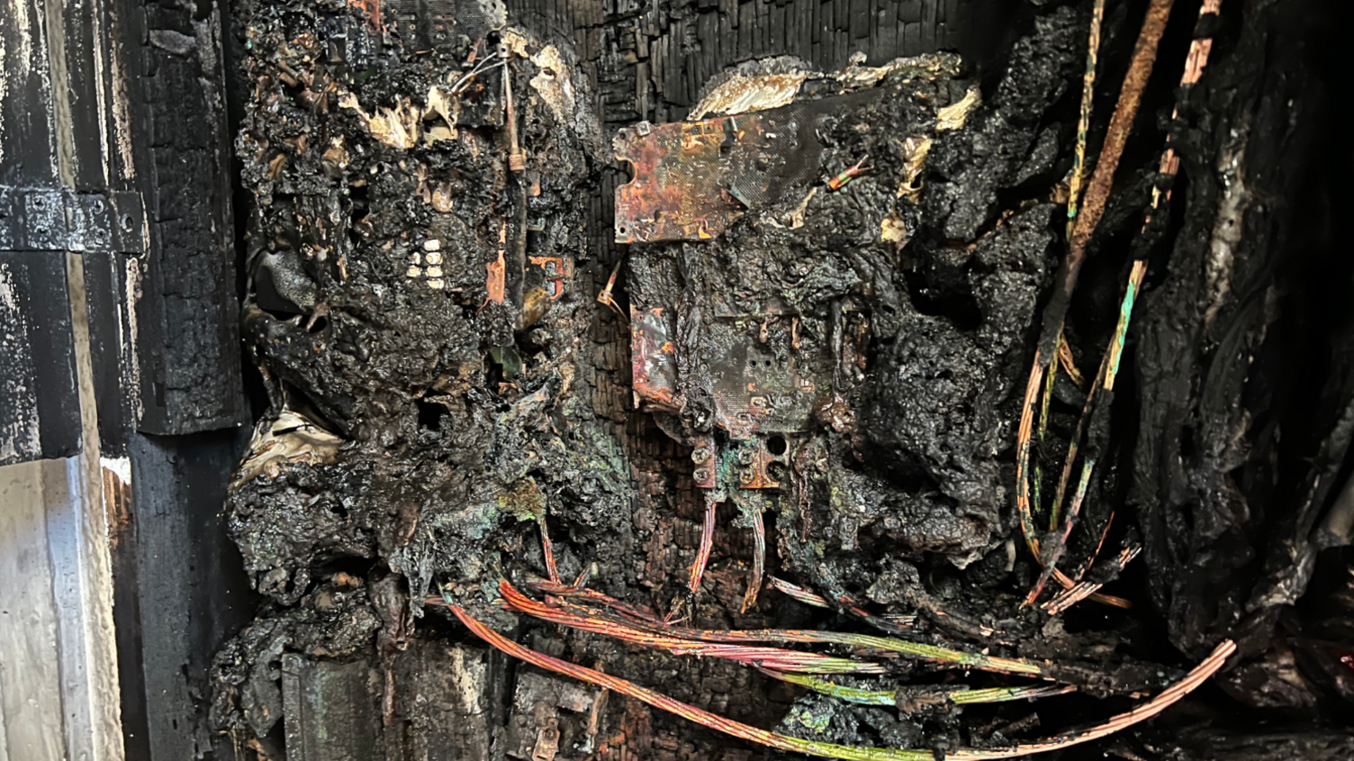 An electrical cupboard fully burnt and black.