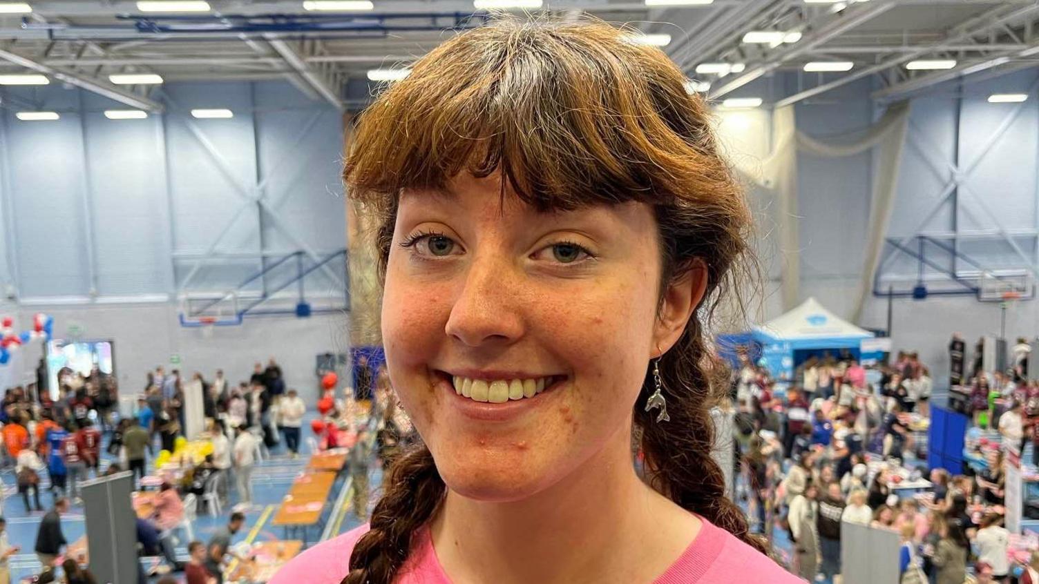 Masters student Caoimhe Conheeney stands on balcony overlooking the Freshers welcome event at Canterbury Christ Church University sports hall