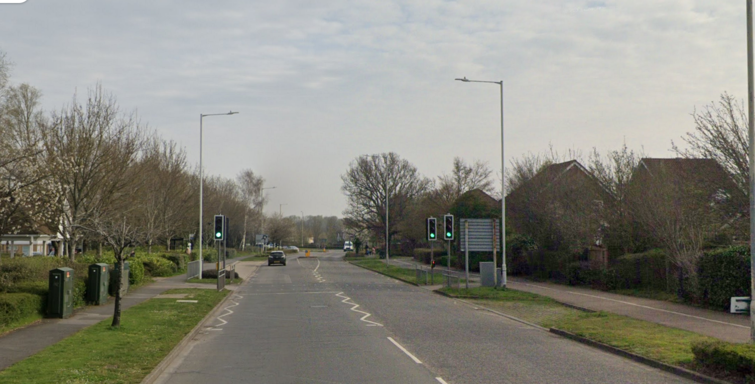 A long straight road with grass either side.