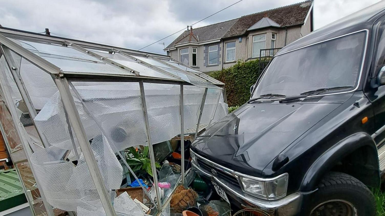 Toyota crashed into the greenhouse, with the side of the greenhouse hanging off