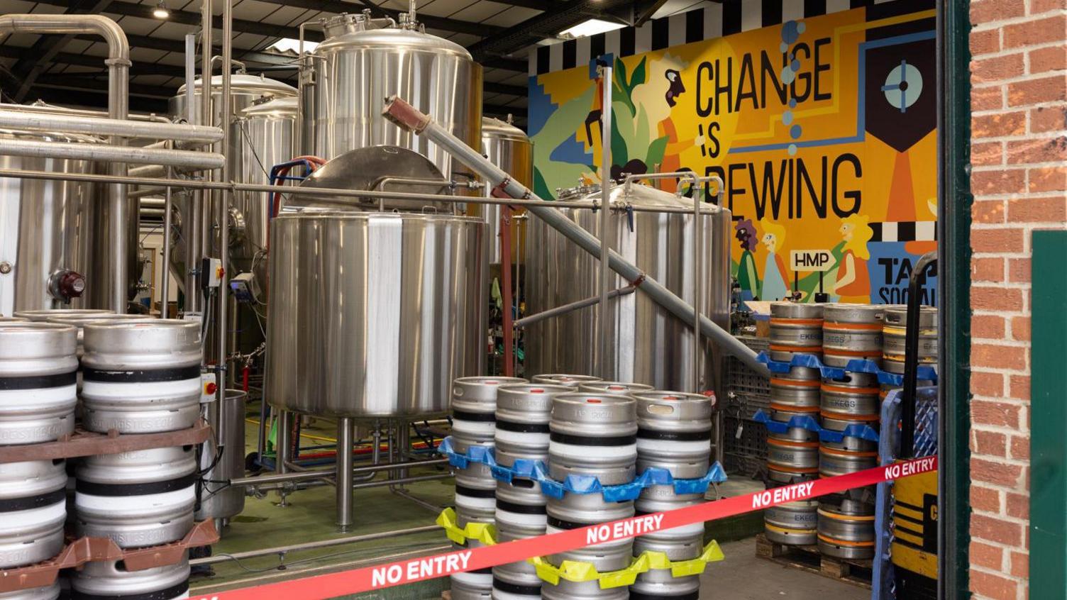 The Tap Social Brewery with a colourful mural on the wall reading "Change is Brewing". There are No Entry signs in front.