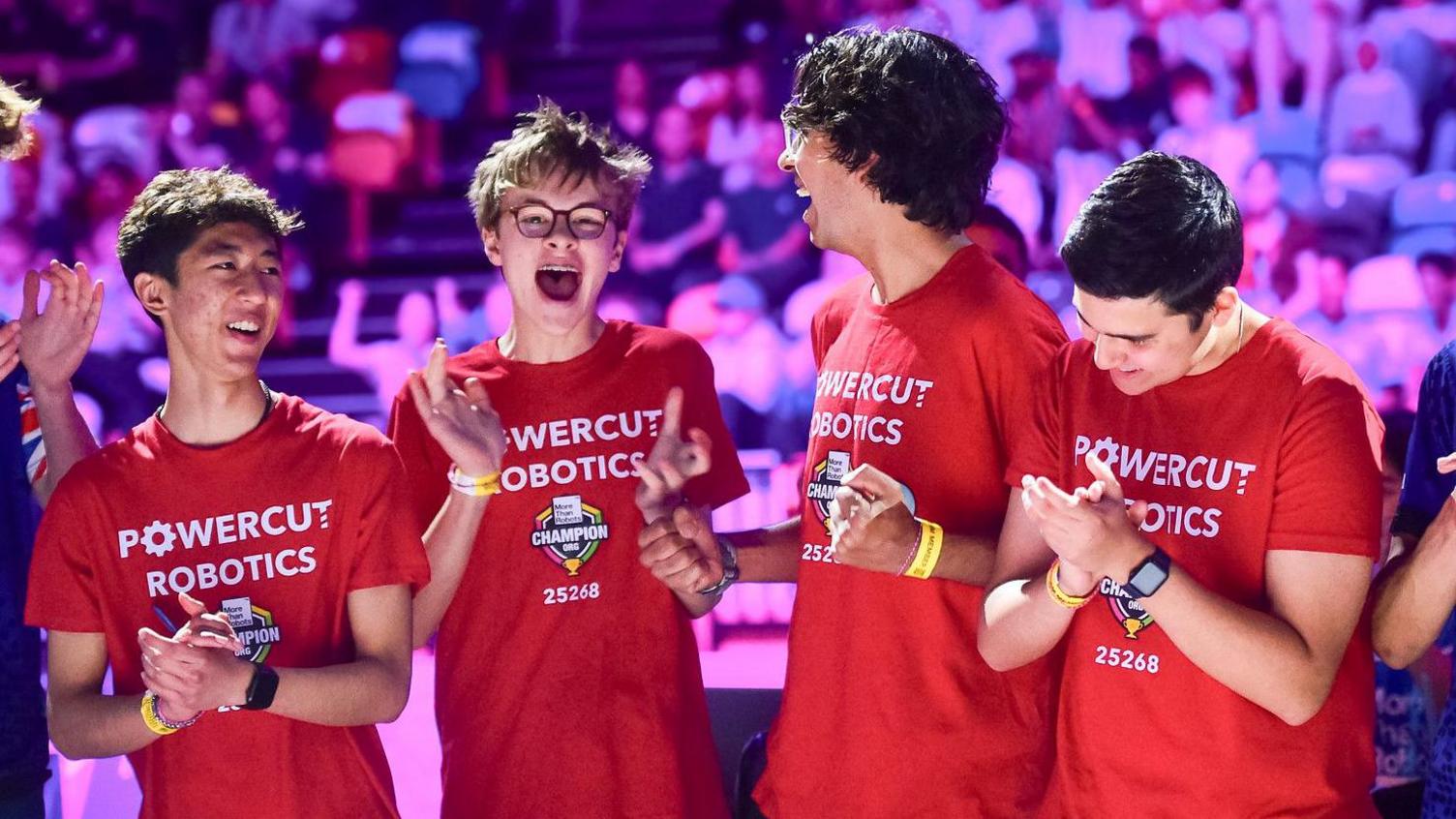 Four boys wearing red shirts celebrate.