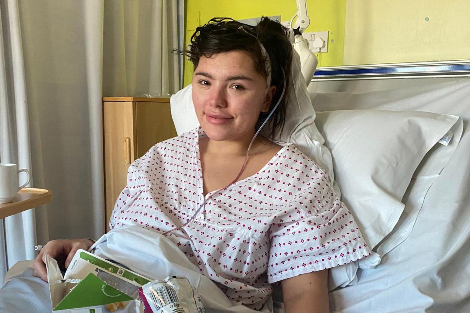 Georgia in a hospital bed with a bandage on her head.