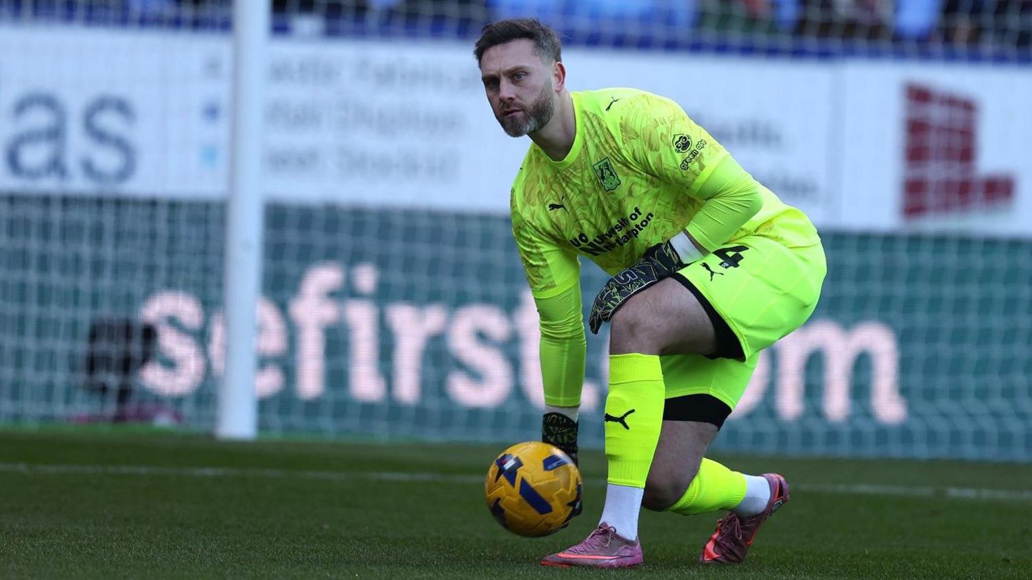 Ross Fitzsimons prepares to roll the ball out to a Northampton Town team-mate