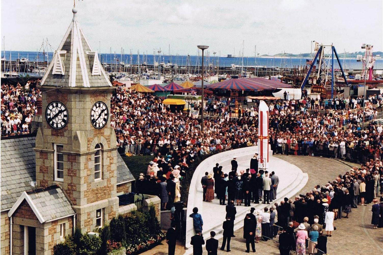 A crowd gathered around the Liberation Monument, which is covered ahead of its unveiling.
