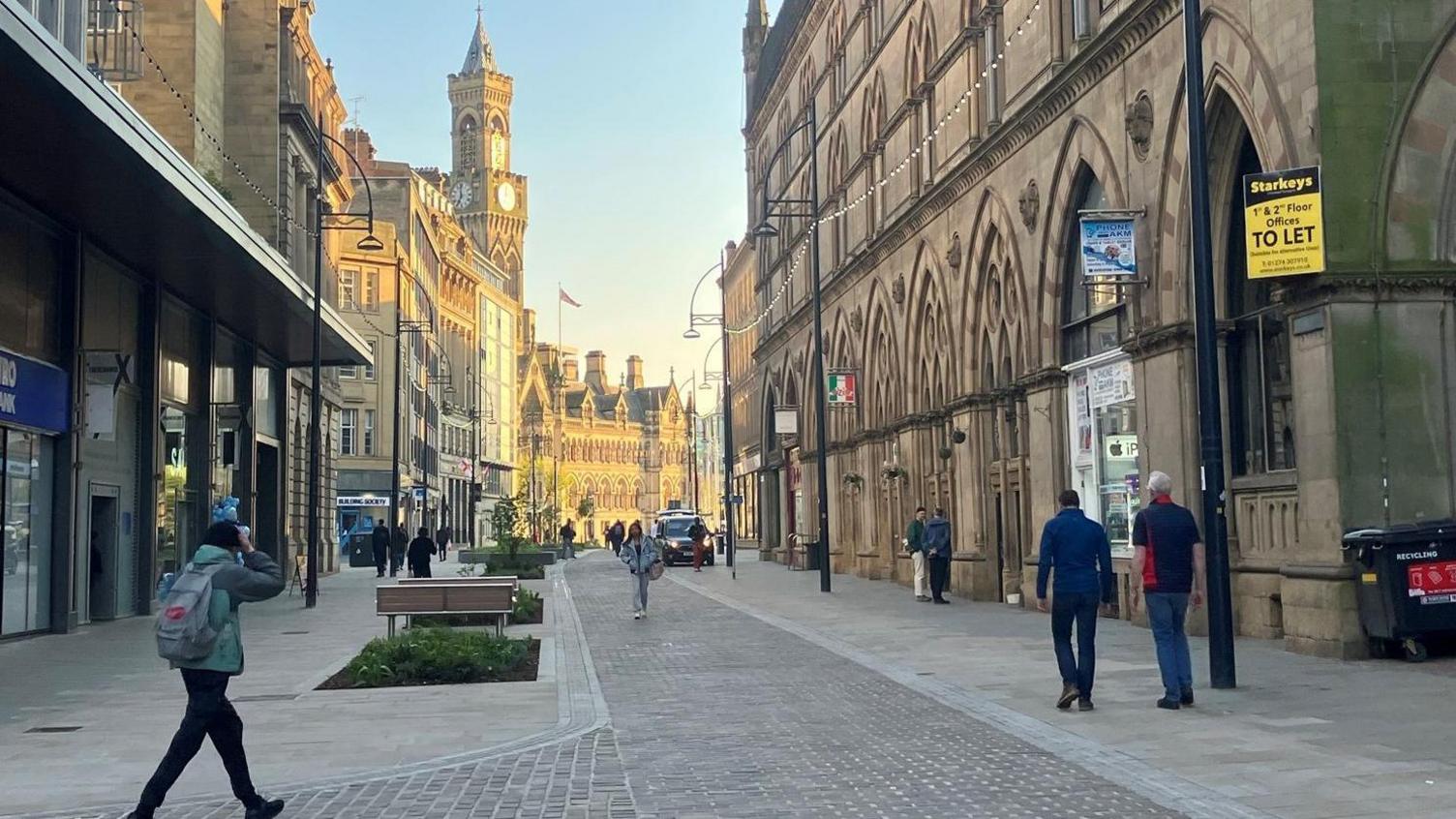 A city centre traffic-free street with large Victorian-style buildings