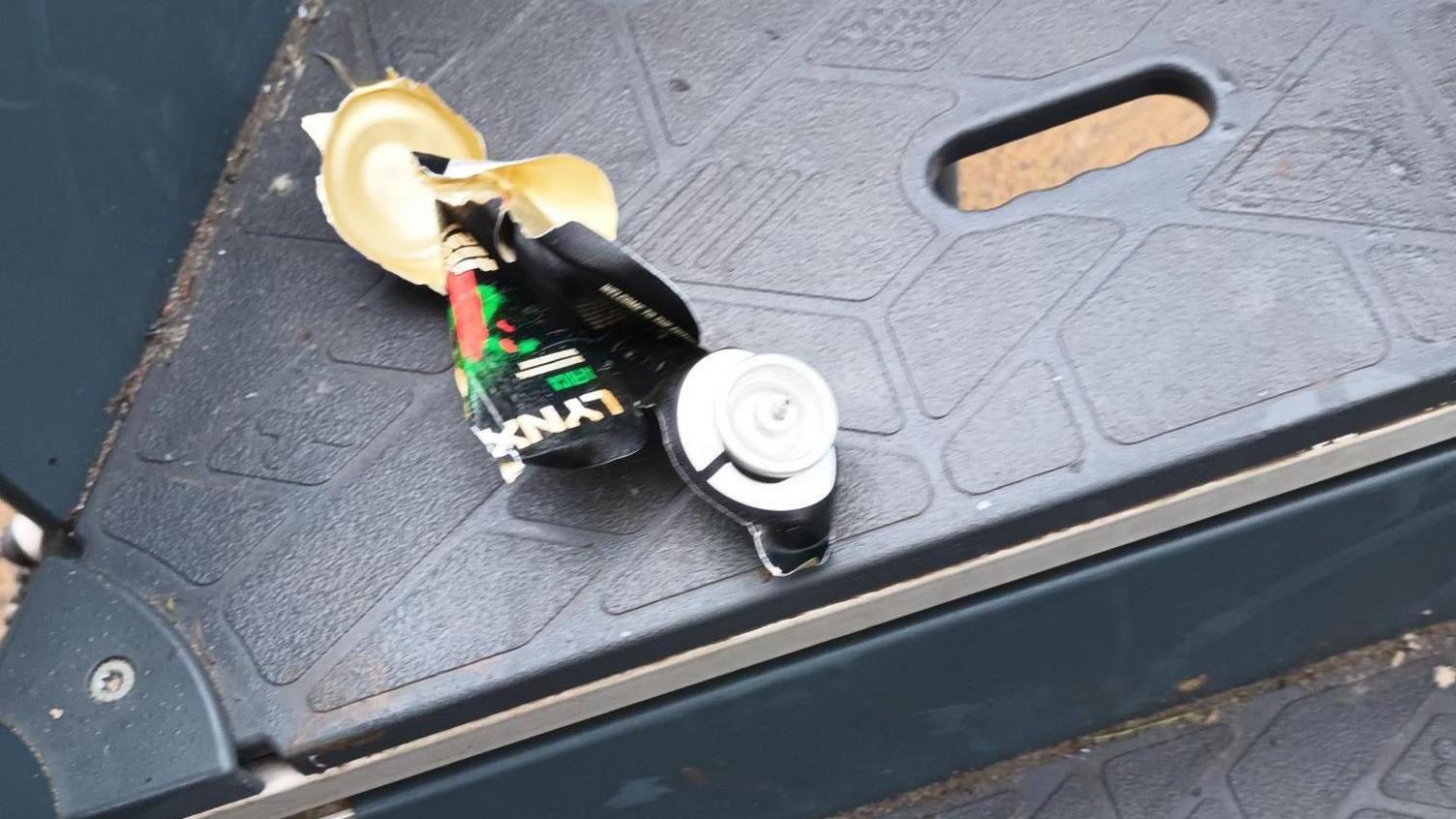 A damaged deodorant can on the play equipment.