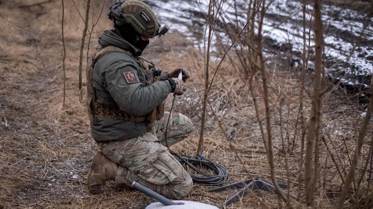 A Ukrainian serviceman of 47th brigade prepares a Starlink satellite internet systems at his positions at a front line, amid Russia's attack on Ukraine, near the town of Avdiivka, recently captured by Russian troops in Donetsk region, Ukraine February 20, 2024.