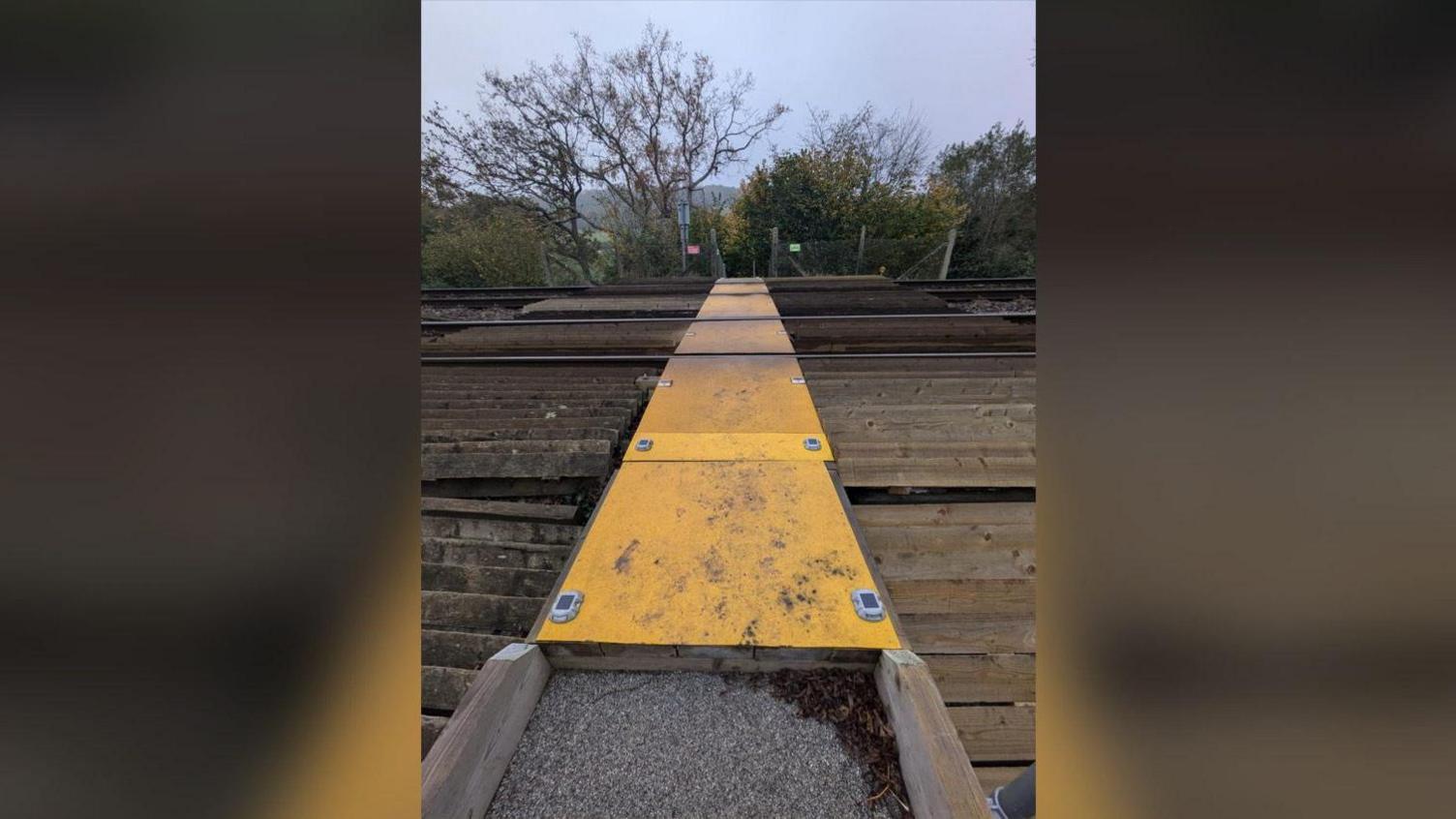 A picture of the unguarded rail crossing that children have to walk along en route to school