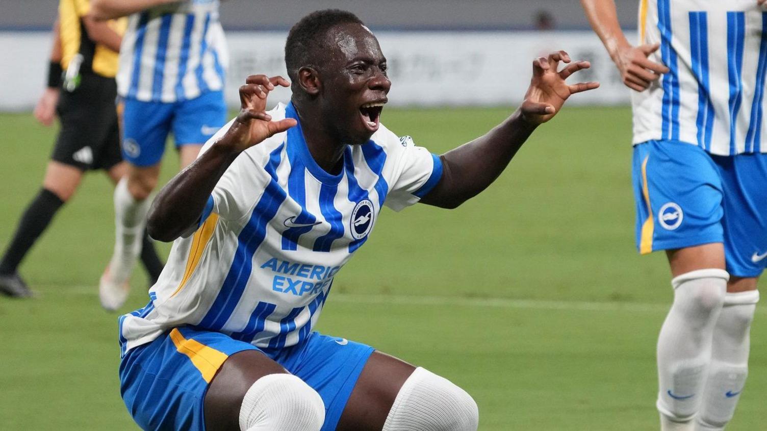 Brighton forward Yankuba Minteh celebrates a goal in a pre-season friendly by making claws with his hands and roaring towards a camera