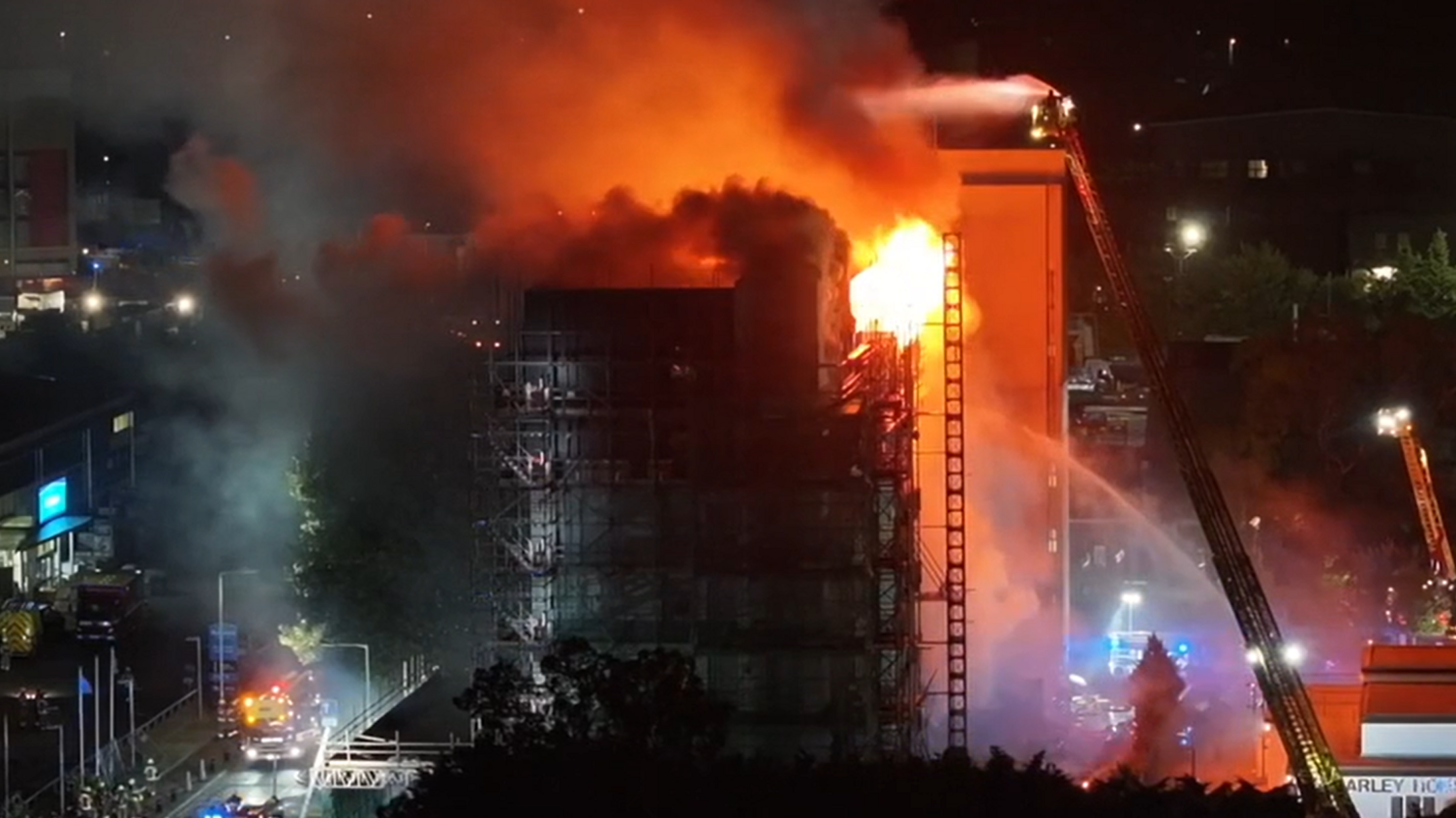 Spectrum House in flames with firefighters attempting to put out the fire with water jets 