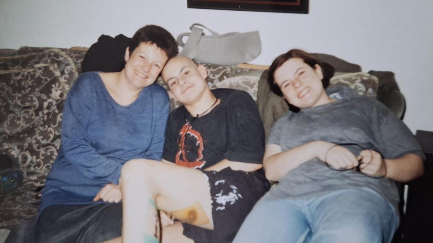 David Wragg (left) sitting on a sofa with his mother Sharon and sister Hermione when he was having cancer treatment 