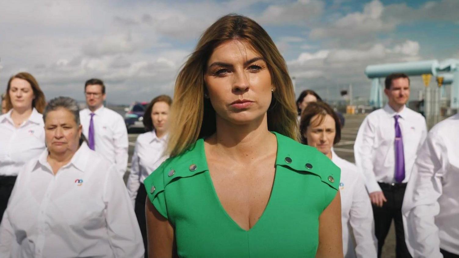 Rachael Flanagan, in a green dress, leads a group of workers from her cleaning company Mrs Buckét.