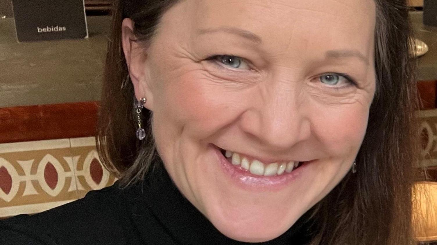 Jennifer Walker smiles in a close-up picture wearing a black jumper 