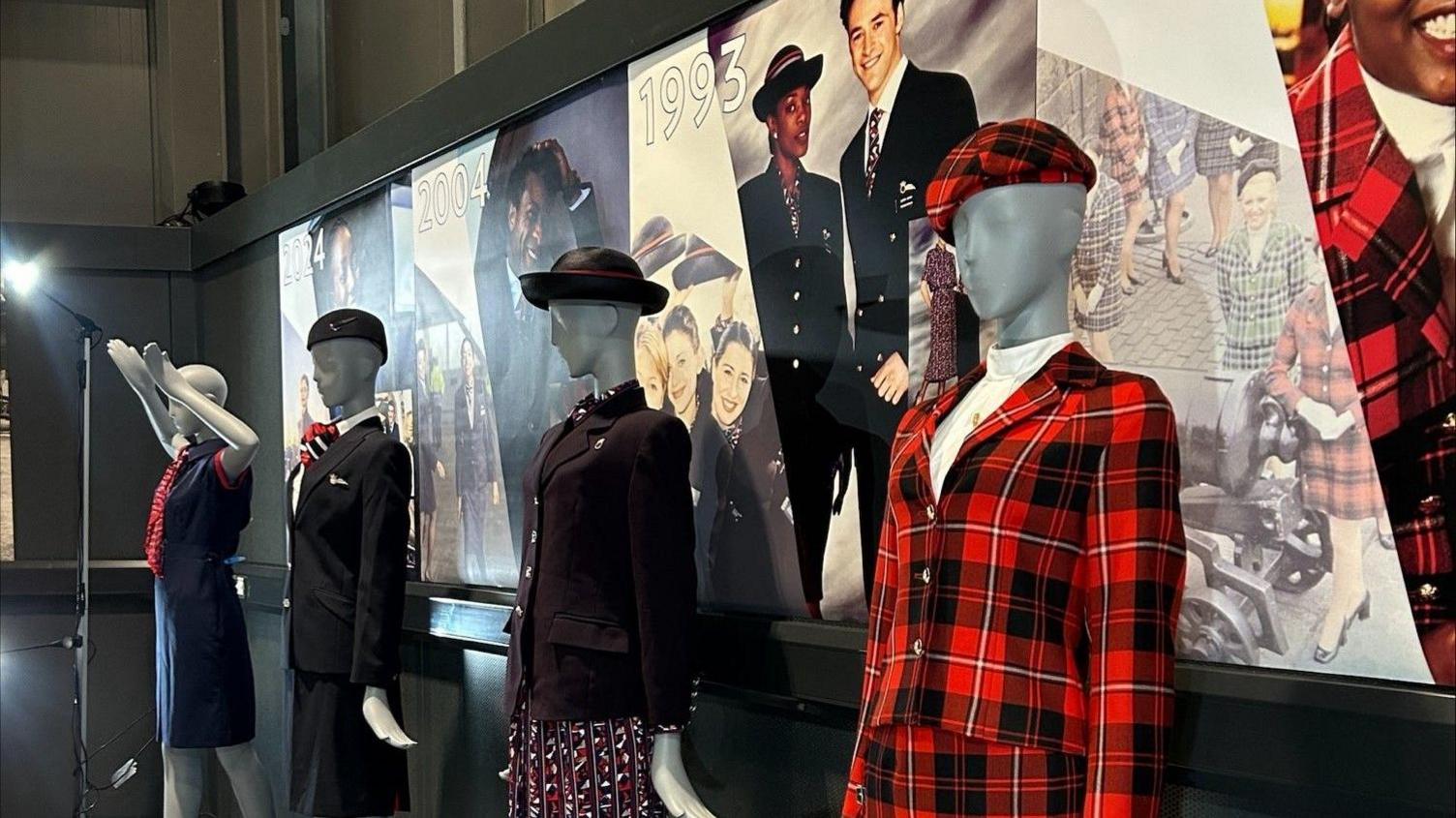 A group of mannequins are lined up at Aerospace Bristol in different uniforms worn by air crew down the years. Closest to the camera is a bold black and red tartan uniform