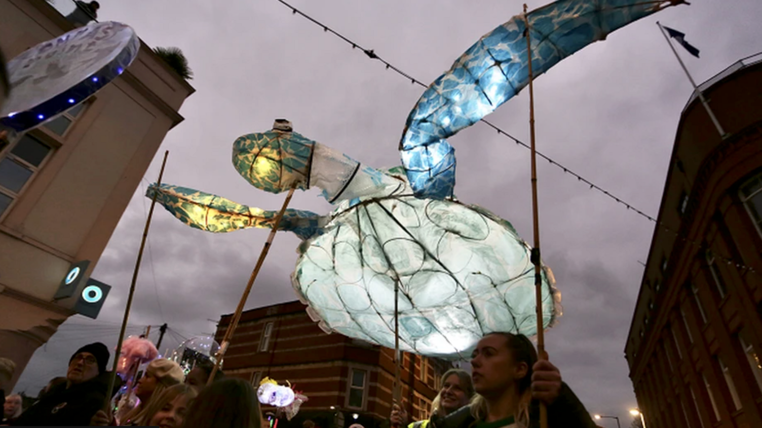 A large turtle lantern being carried by festival goers during the annual Bedminster Winter Lantern Parade