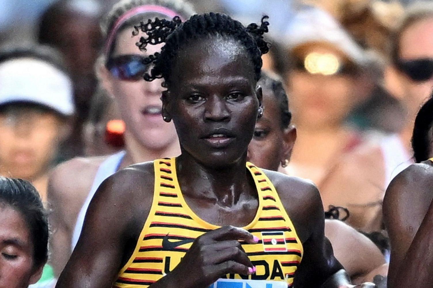 Rebecca Cheptegei takes part in a race wearing a yellow top with black and red stripes.