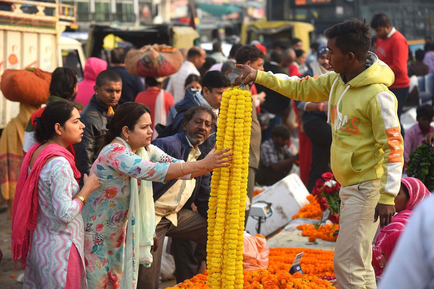 People buy marigold flowers, fresh roses and garlands at the flower marker in Gurugram