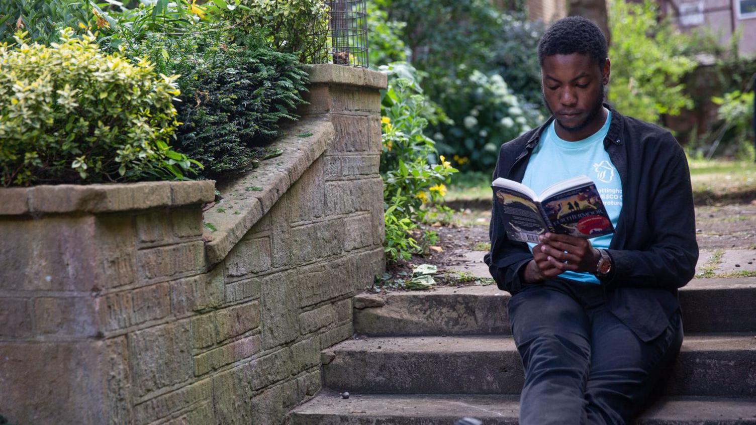 A man sitting on steps reading