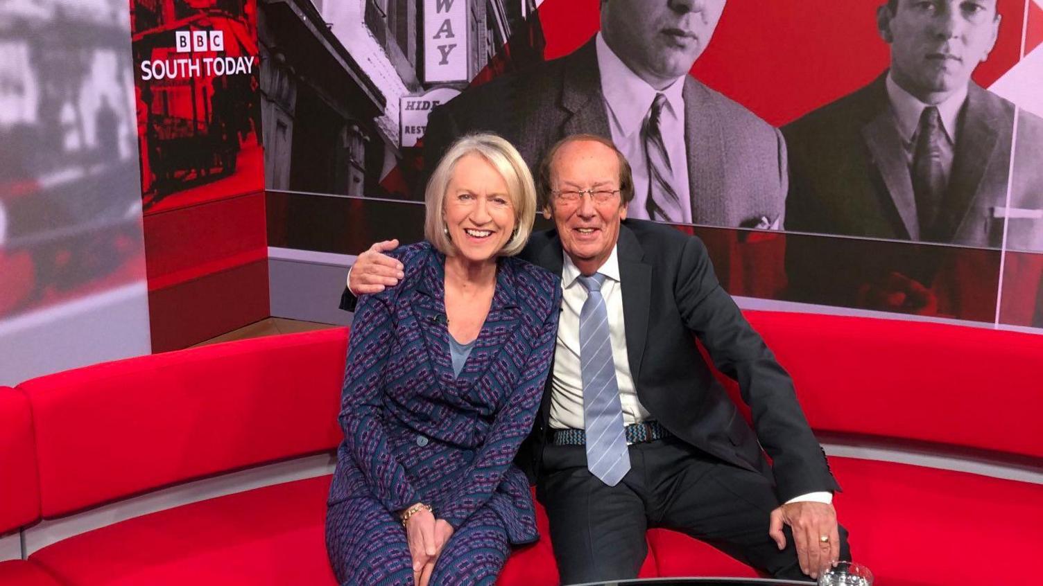 Fred Dinenage and Sally Taylor are sitting next to each other on the red south today couch.
