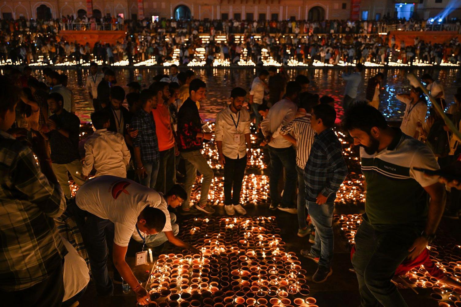 People light earthen lamps on the banks of Sarayu river in Ayodhya on November 11, 2023