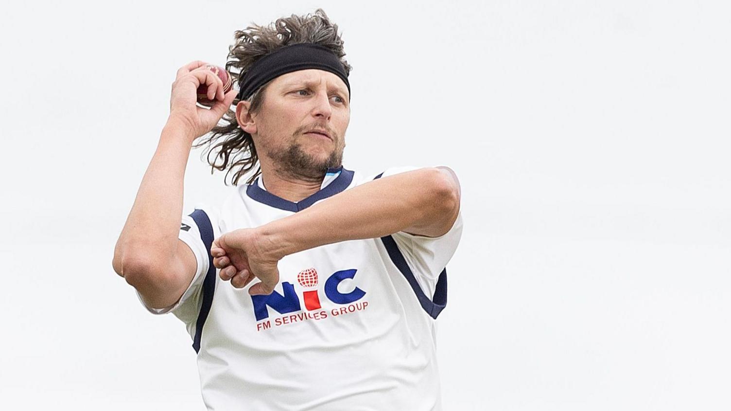 Yorkshire's Jack White, wearing a headband, bowls against Essex in March 2026