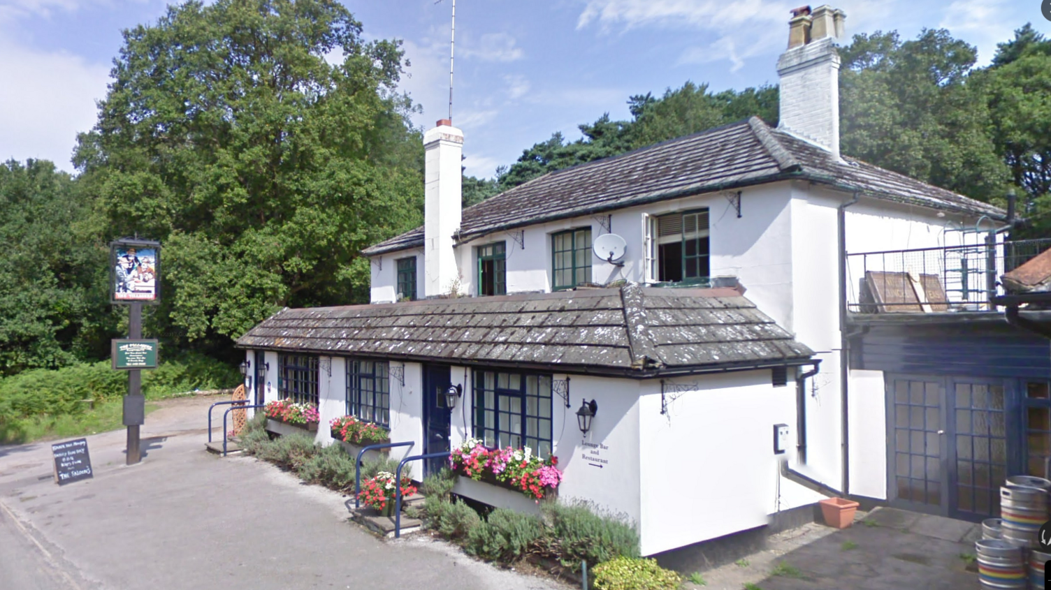 A white two-storey building with flower boxes in its front windows. There is a sign in the front reading 'The Villagers'