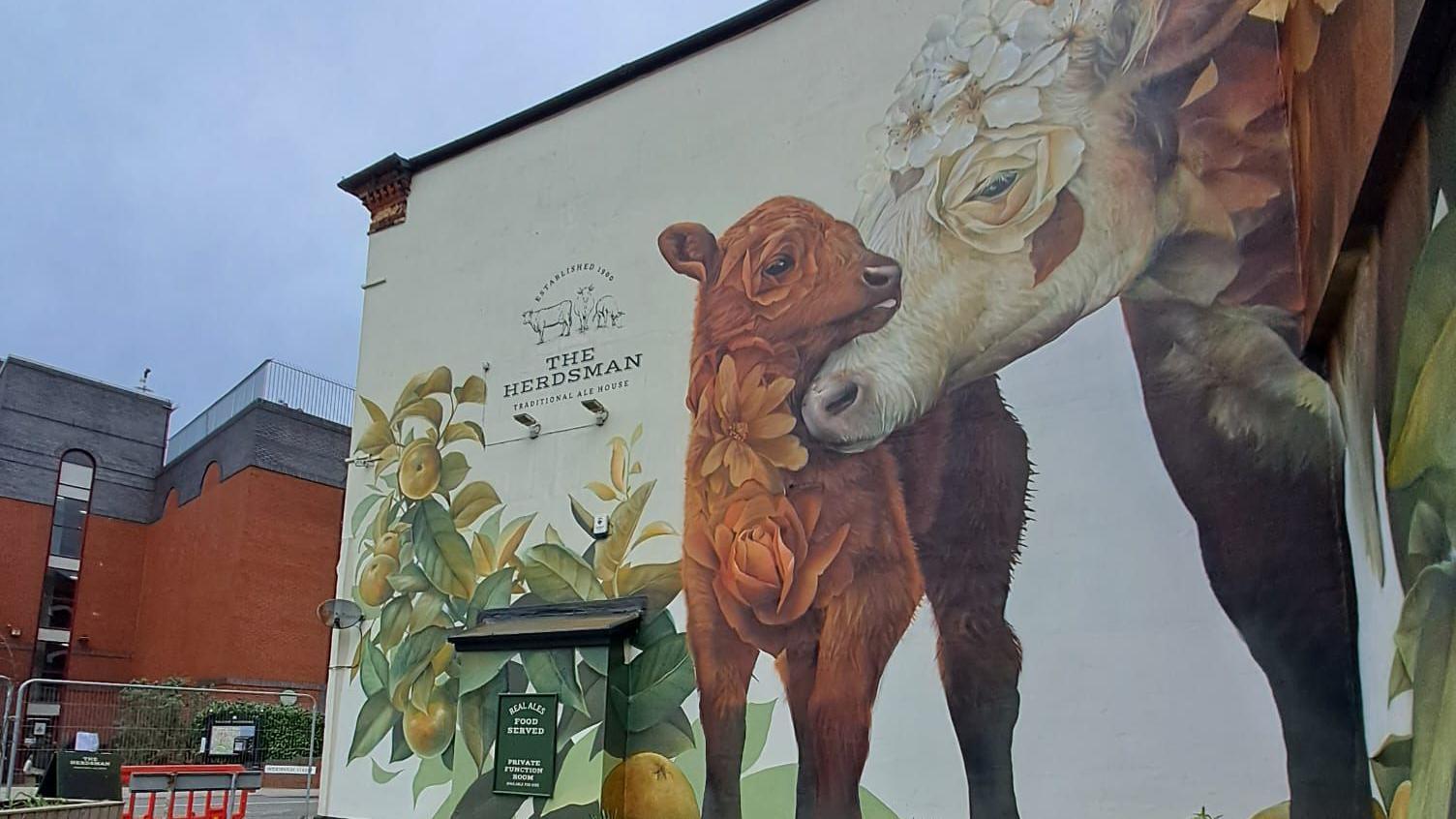 Mural depicting two cows on the side of a building