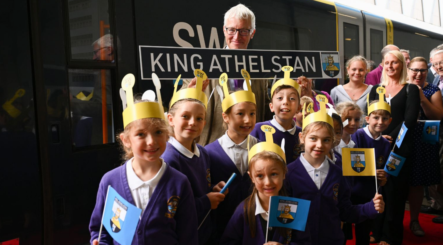 Tom Holland with the new sign and some school children 