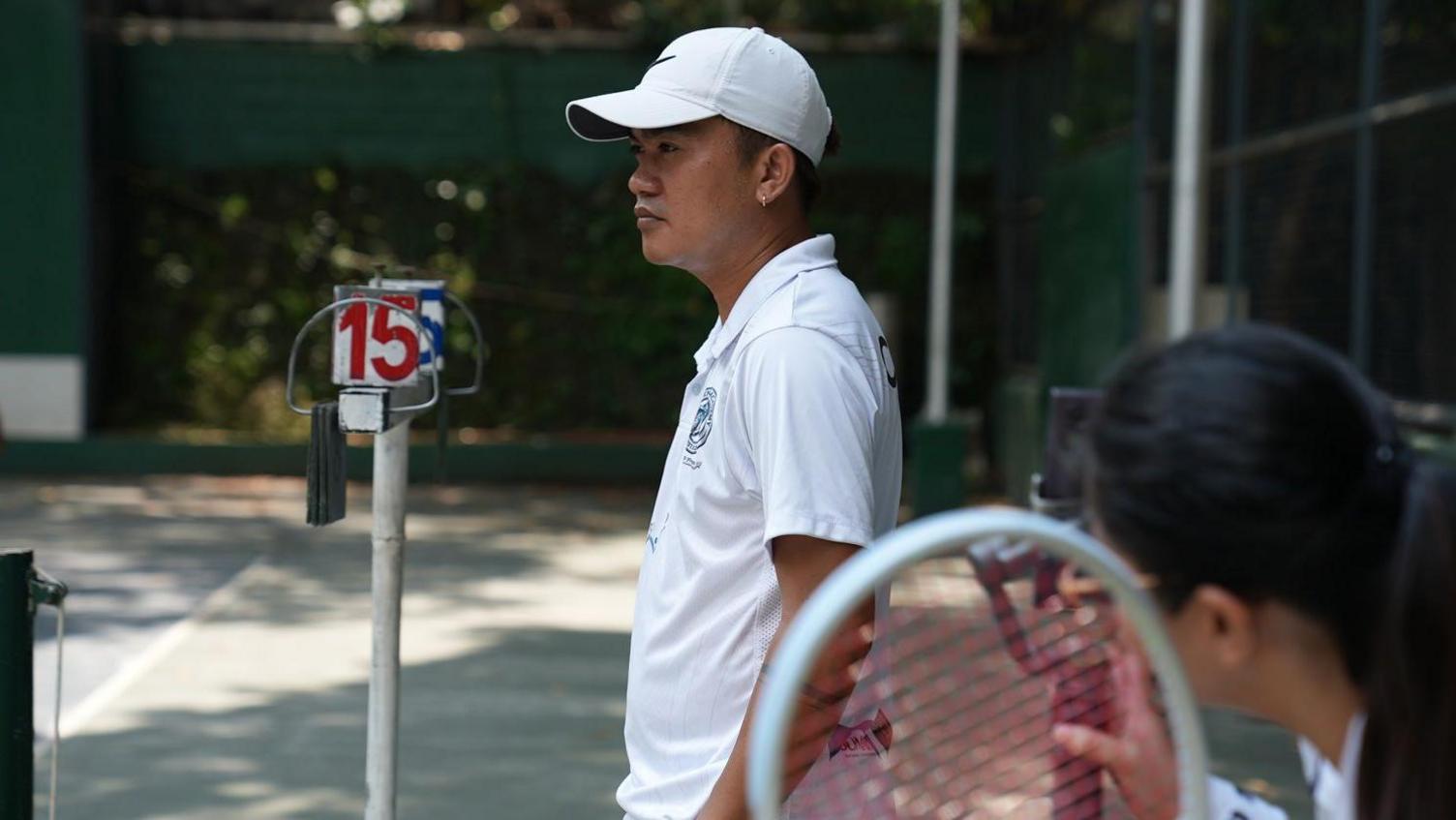Tennis coach Jovy Barce standing in a tennis court in Manila