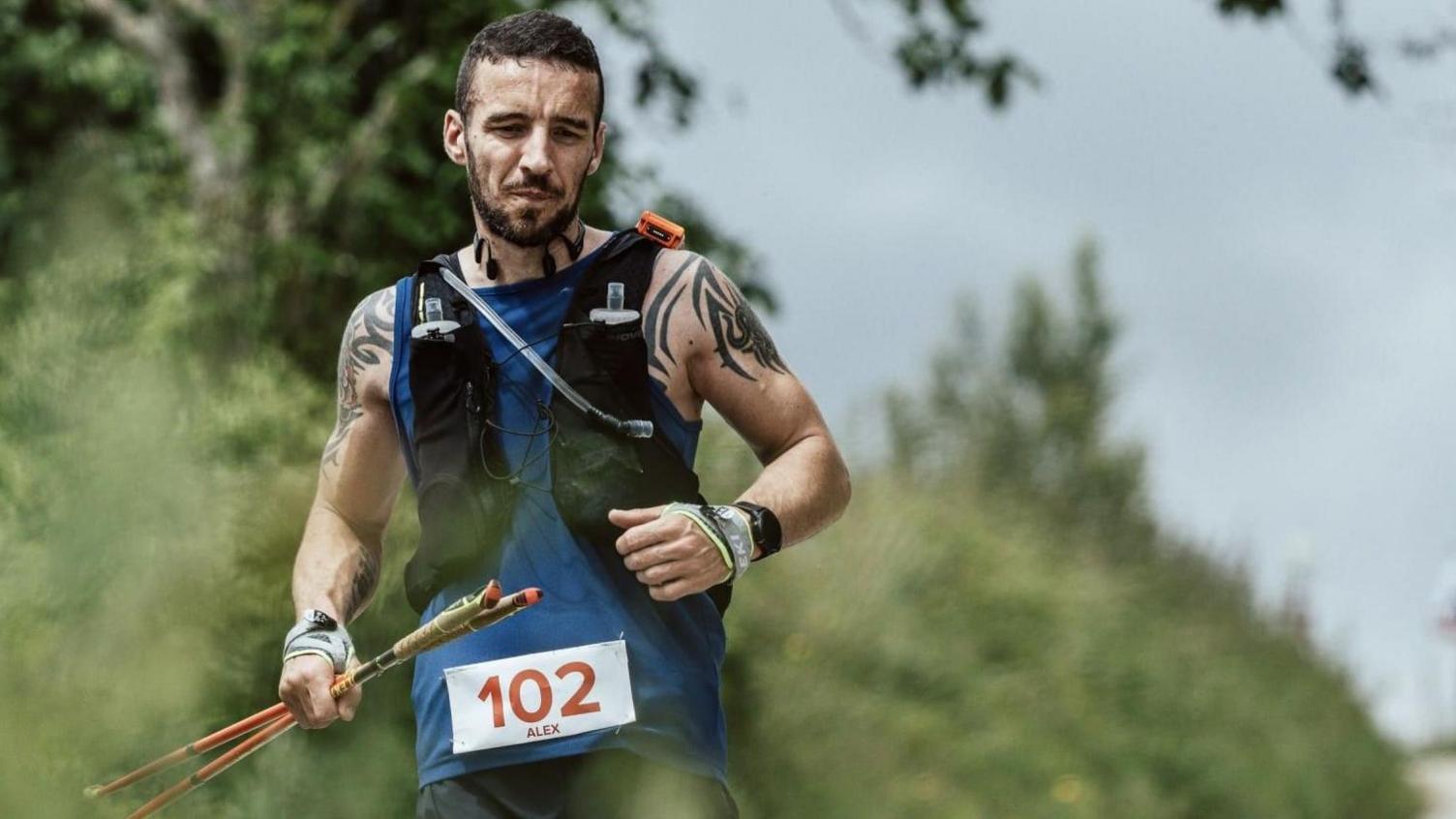 Alex Bance running, wearing sports gear including a specialist backpack with water bottles