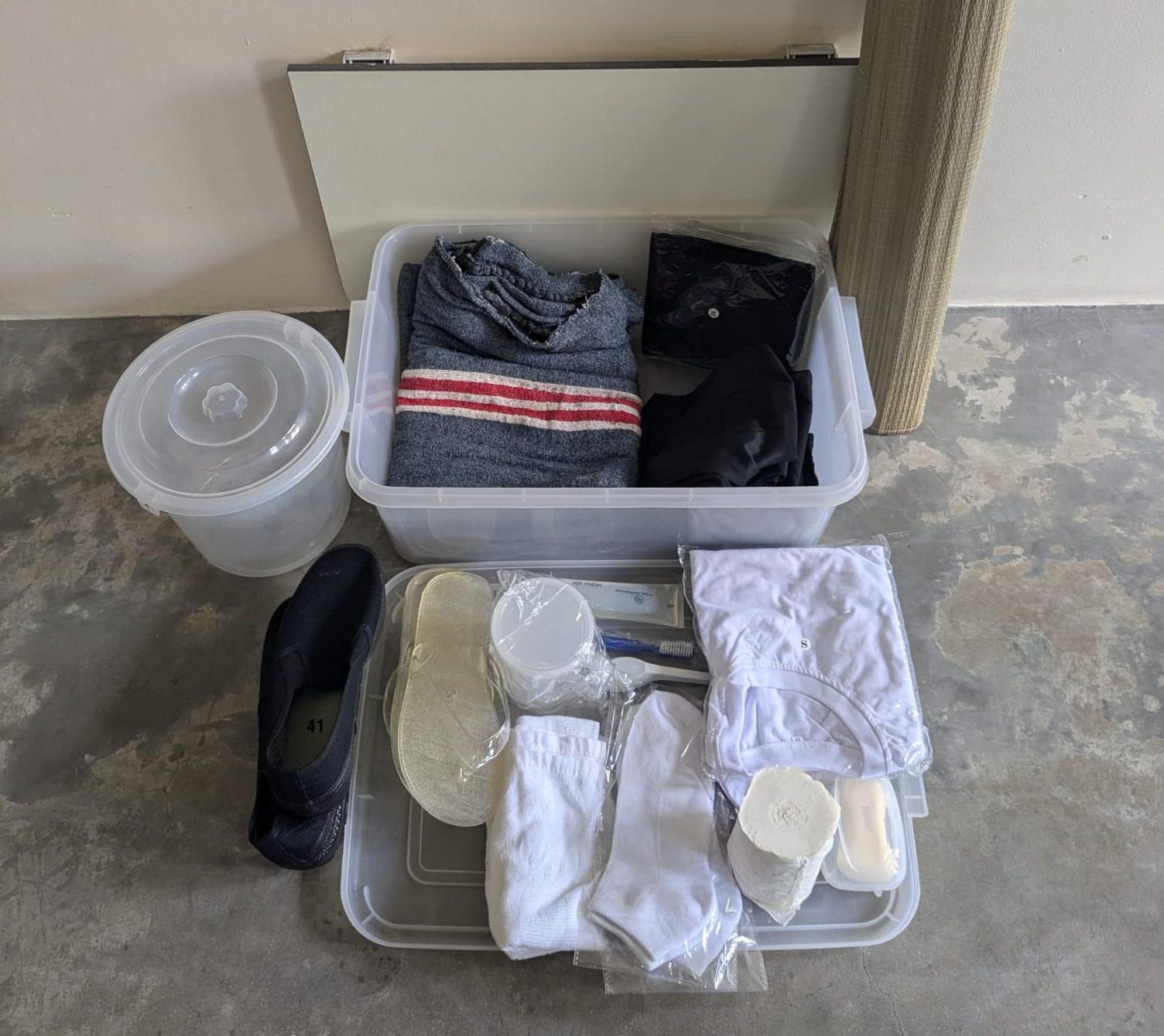 Inmates are given items including a T-shirt and socks, and a rush mat on which to sleep