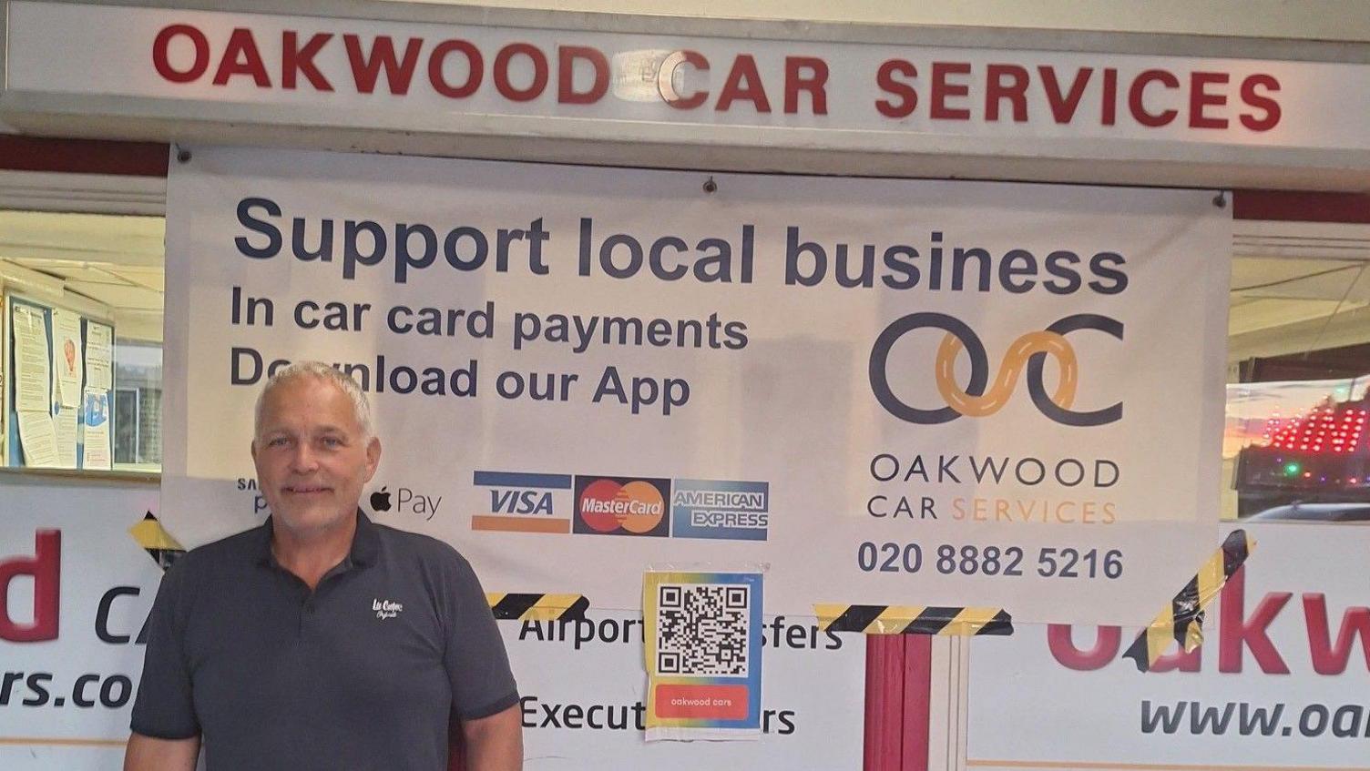 A man stands in front of a taxi office