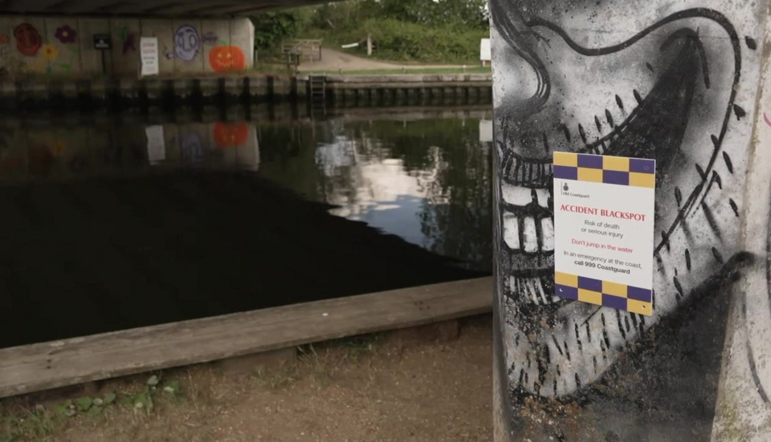 A sign, roughly A4 sized, which reads Accident Blackspot risk of death or serious injury do not jump in the river, in an emergency at the coast call 999 Coastguard