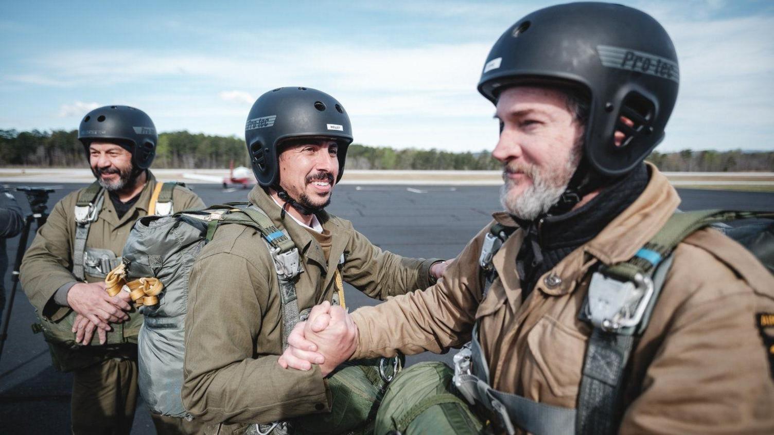 Three members of the Band of Brothers cast shake hands