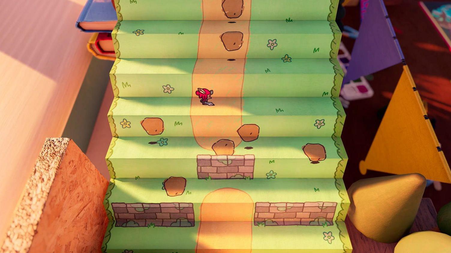 A 2D character stands on a piece of cardboard decorated with a drawing of a grassy hill. The corrugated material gives the hill a 3D effect, and the main character folds with the paper as he passes through a crease. 