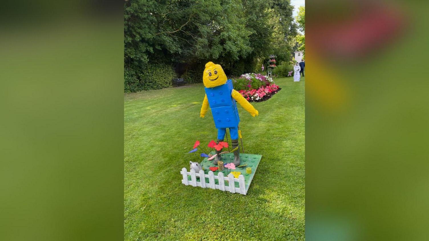 A lego scarecrow with a yellow head and blue body