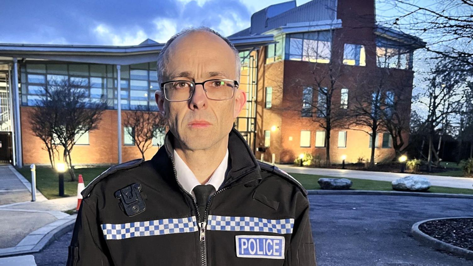 Chief Constable Paul Sanford wearing a black police jacket and stood in front of Wymondham police headquarters