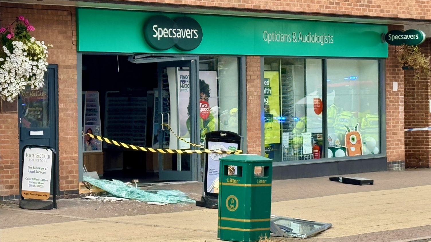 Specsavers Opticians in Blaby, Leicestershire, with damaged front entrance after a car crashed into it.