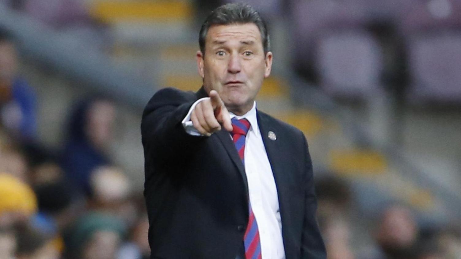 Aldershot manager Tommy Widdrington pointing towards the camera from the sidelines