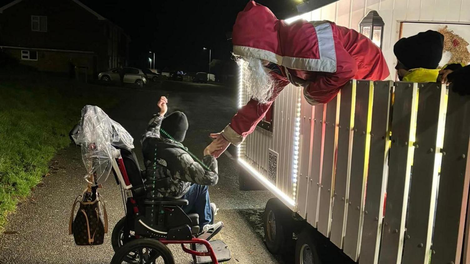 Santa shaking hands with a young visitor