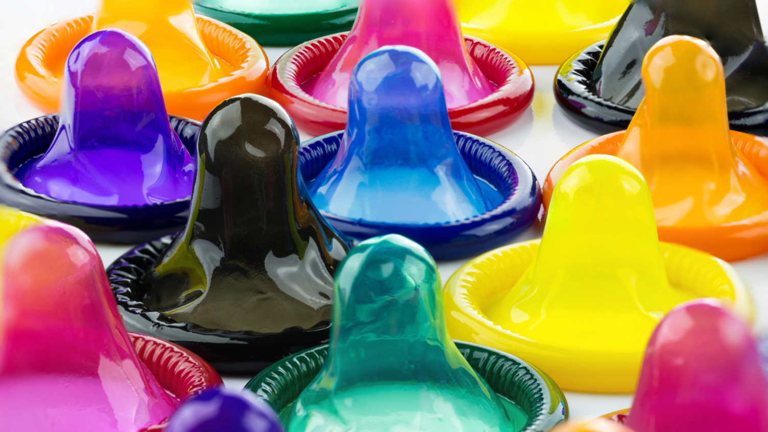 Condoms in various colours on a white background