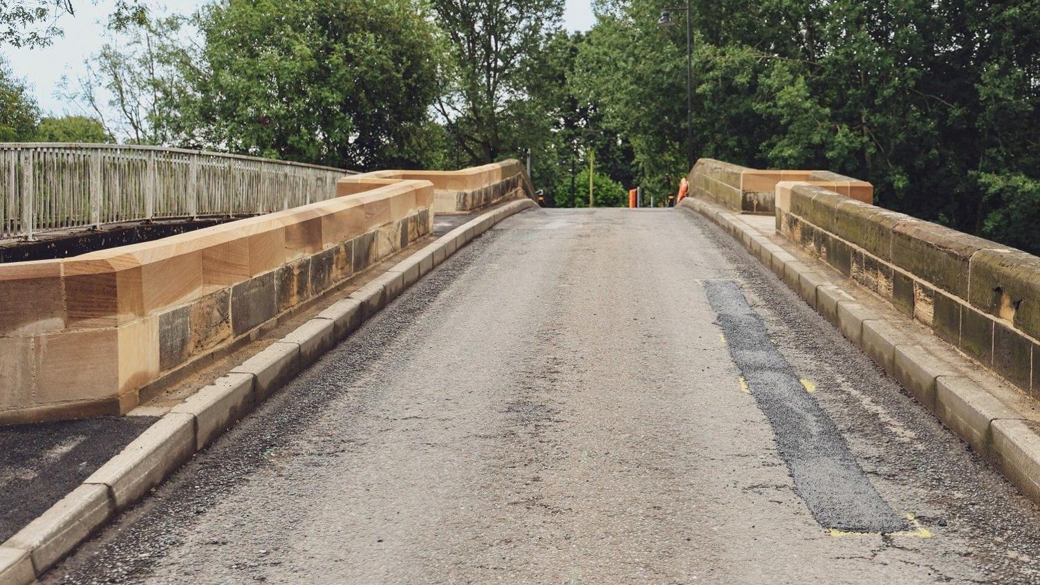 A driver's view of the approach to the bridge, with new stone parapets on either side