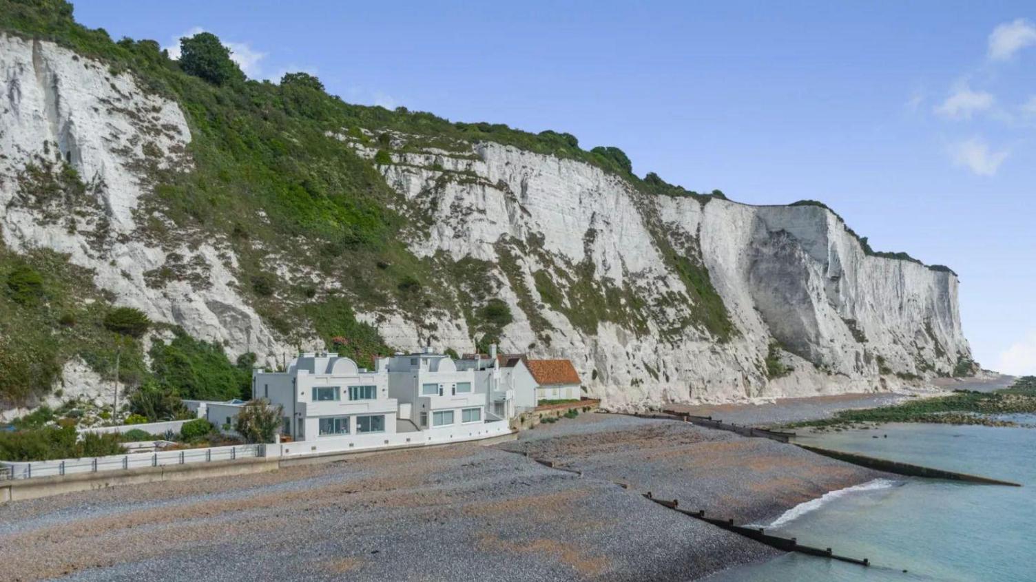 A wide shot of the 1920s white art deco style Mermaid Cottage perched underneath the White Cliffs at St Margaret's Bay