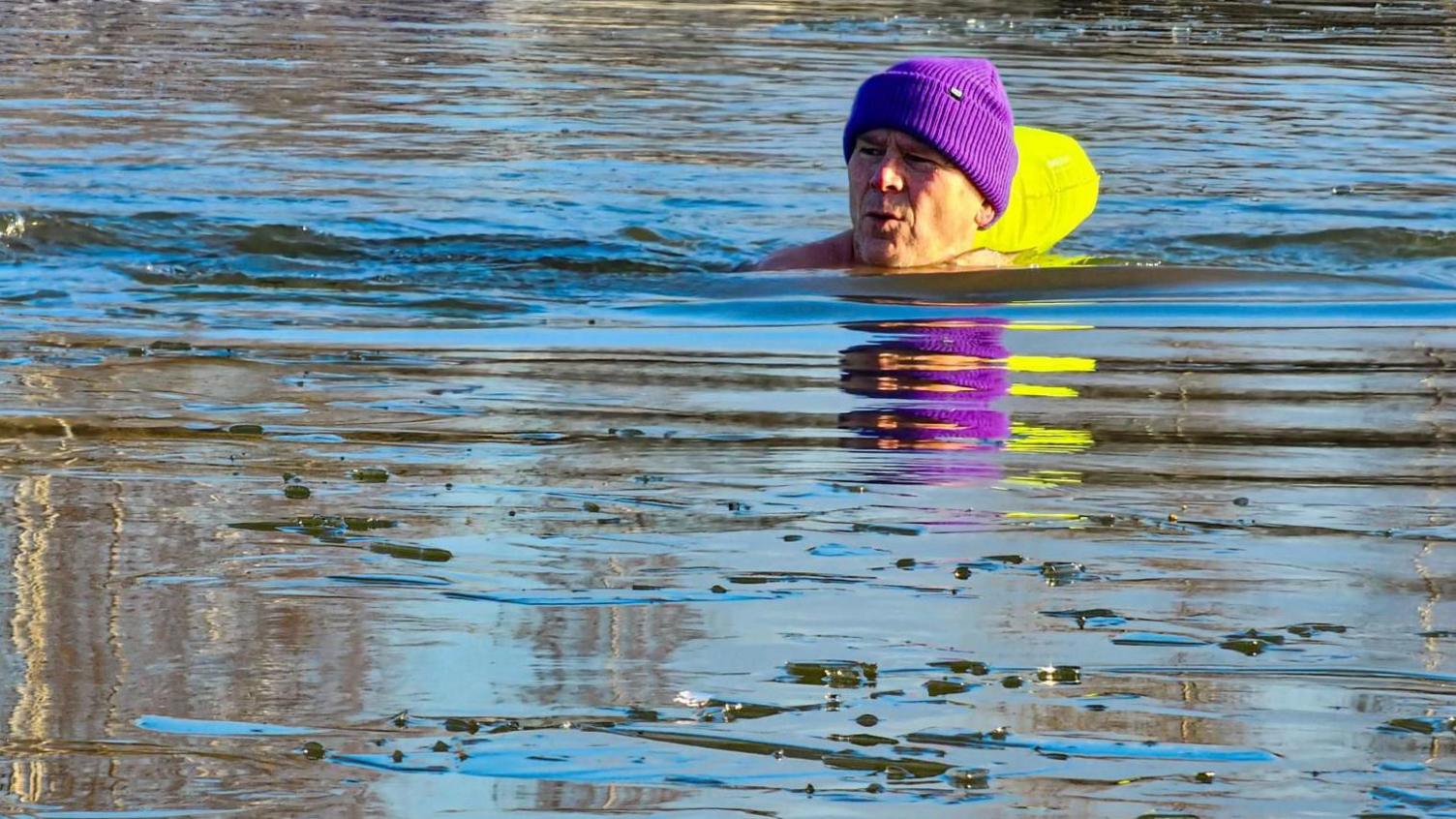 Simon Perkins swimming at Spring Lakes in a purple hat